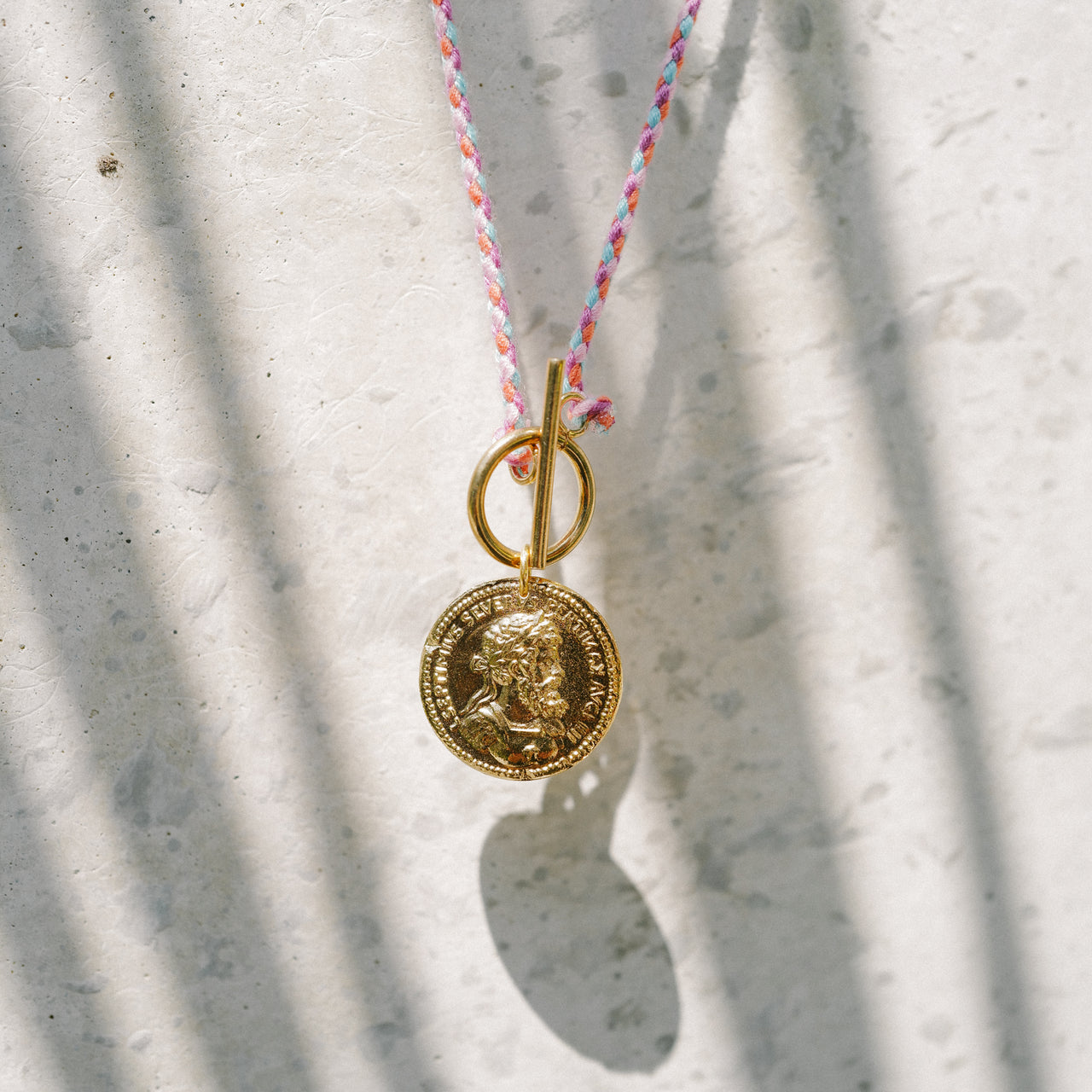gold plated medal on a pink cotton cordon handmade by 4 crosses in paris